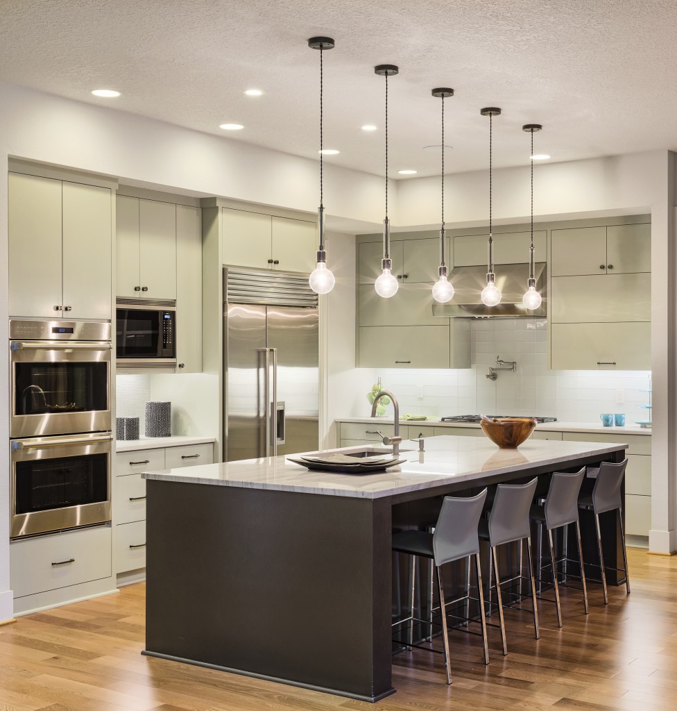 Kitchen with Island, Sink, Cabinets, and Hardwood Floors in New Luxury Home